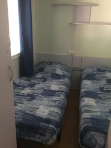 a bedroom with two beds in a room with a window at Mobil home PAPILLON in La Celle-sous-Gouzon