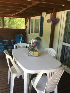 a white table with white chairs on a porch at Mobil home PAPILLON in La Celle-sous-Gouzon