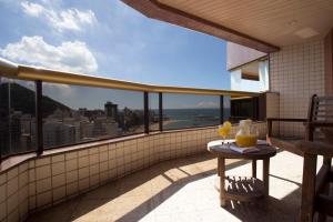 balcón con mesa y vistas a la ciudad en Quality Suites Vila Velha, en Vila Velha