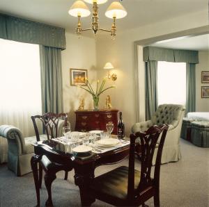 een woonkamer met een tafel en stoelen en een bed bij Casa Corp Boutique Suites in Condesa in Mexico-Stad
