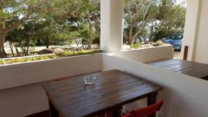 a wooden table with a wine glass on a balcony at Appartamenti Jeko in Lampedusa