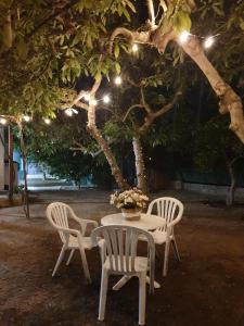 ein Tisch mit drei Stühlen und ein Baum mit Lichtern in der Unterkunft Mi niña Lola in Fuengirola