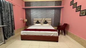 a bedroom with a bed and a pink wall at Comfort home stay in Sivasagar +5 photos