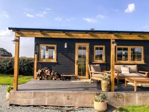 a black tiny house on a wooden deck at The Meadow Snug in Baschurch