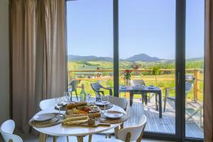 a dining room with a table with food and a balcony at POLANA PIORUN Domki całoroczne w Beskidach in Krynica Zdrój