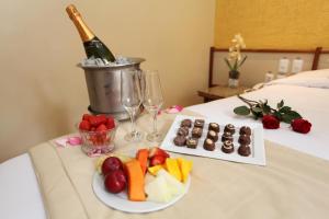 a table with a bottle of champagne and a plate of fruit at Mengo Palace Hotel in Rio de Janeiro