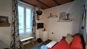 a living room with a red couch and a window at La casa di E in Sesto Fiorentino
