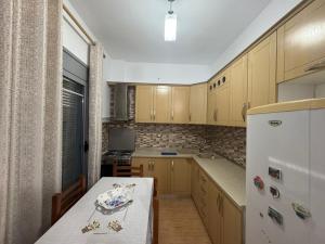 a kitchen with a table and a white refrigerator at Vila Brilant in Vlorë +36 photos