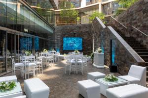 un ristorante con tavoli e sedie bianchi e un edificio di Hyatt Centric San Isidro Lima a Lima