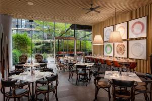 un ristorante con tavoli, sedie e ampie finestre di Hyatt Centric San Isidro Lima a Lima Altre 37 foto