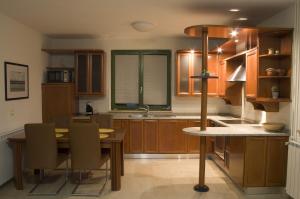 a kitchen with wooden cabinets and a table and chairs at Apartments Tim in Portorož