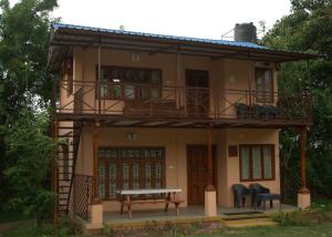 uma casa com uma varanda e uma mesa de piquenique em Tamarind Tree Masinagudi em Masinagudi