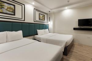 a hotel room with two beds and a tv at Bella Rosa Trendy Hotel & Spa in Hanoi