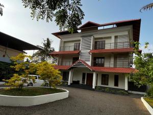 ein Gebäude mit einem davor geparkten Auto in der Unterkunft Matts Homestay Alleppey in Jāmb
