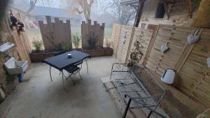 a patio with a table and chairs and a fence at Gîte La Giroflee in Meillonnas +6 photos