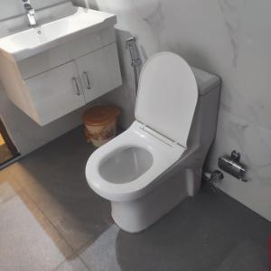 ein Badezimmer mit einer weißen Toilette und einem Waschbecken in der Unterkunft Matts Homestay Alleppey in Jāmb + 10 Fotos