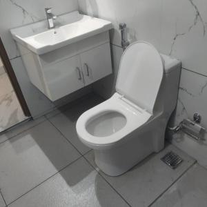 ein Badezimmer mit einer weißen Toilette und einem Waschbecken in der Unterkunft Matts Homestay Alleppey in Jāmb