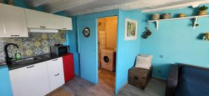a kitchen with white cabinets and a blue wall at Spectacular Seaview & Sunset Studio in Old Town in Menton