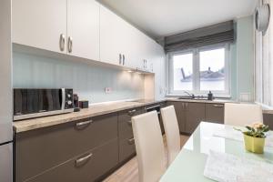 a kitchen with a table and a microwave at Quebec Flat in Oradea +7 photos
