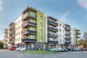 a green building with cars parked in a parking lot at Quebec Flat in Oradea