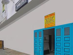 a building with blue doors and a sign on it at OYO 92403 Gatsu Homestay in Medan