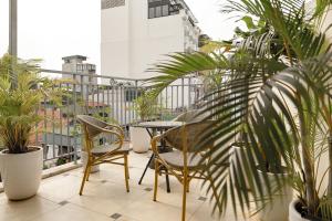 a balcony with chairs and a table and plants at Bella Rosa Trendy Hotel & Spa in Hanoi