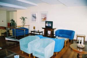 a living room with blue chairs and a table at Areia Dourada in Porto Santo