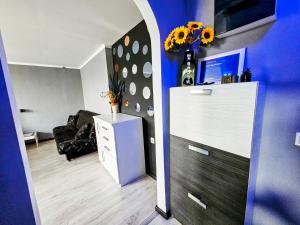 a living room with a white dresser and a blue wall at Savić Apartment CENTER - PARKING FREE in Niš