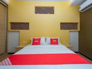 a bedroom with a large bed with red pillows at OYO 90324 Muar Station Hotel in Pantai Cenang
