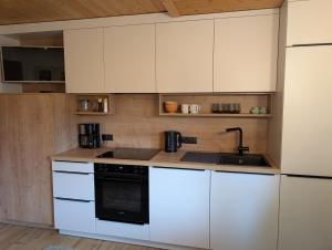 a kitchen with white cabinets and a black stove top oven at Appartement Hartl in Filzmoos +31 photos