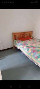 ナイロビにあるDam estate 20のベッドルームにカラフルな掛け布団付きのベッド1台