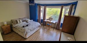 a bedroom with a bed and a desk and a window at Great stay in a beautiful and cosy house in Bournemouth