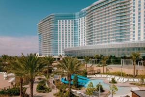 a large building with palm trees and a water park at Gaylord Pacific Resort & Convention Center in Chula Vista