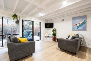 a living room with two couches and a tv at The River Nook on Hurst in Ocean Grove