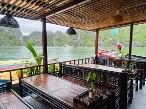 a porch with benches and a view of the water at Eco Floating Stay Cai Beo in Cat Ba