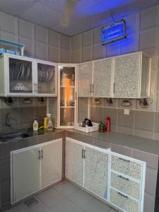 a kitchen with white cabinets and a refrigerator at أستراحة السعادة in Jalan Bani Buhassan +9 photos