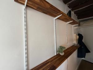 a room with a white wall with a wooden shelf at Chez Eric Studio au coeur de Châtelet in Paris