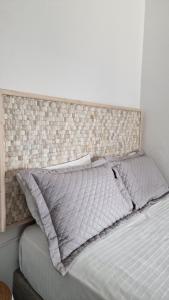 a bed with a padded headboard and pillows on it at Angel's Petit House in Triovasálos