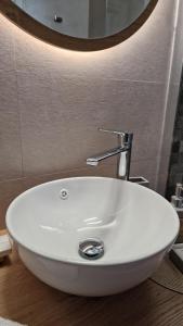 a white sink in a bathroom with a mirror at Angel's Petit House in Triovasálos +5 photos