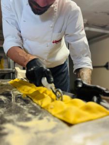 a chef cutting up food with a pair of scissors at Hotel Butterfly Wellness & Spa in Rimini