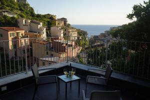 balcón con mesa y 2 copas de vino en Locanda Ca Da Iride, en Riomaggiore