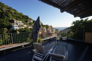 a balcony with chairs and a table and an umbrella at Locanda Ca Da Iride in Riomaggiore