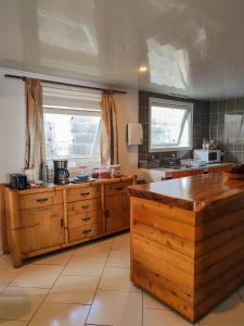 una grande cucina con armadi in legno e una grande finestra di Hava'e Lodge TEAHUPOO a Teahupoo