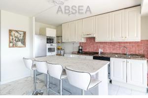 eine Küche mit Marmoroberflächen und weißen Schränken in der Unterkunft 2 pièces vue mer Nice ouest in Nizza