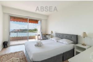 ein Schlafzimmer mit einem großen Bett mit einem großen Fenster in der Unterkunft 2 pièces vue mer Nice ouest in Nizza + 6 Fotos