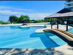 ein großes Schwimmbecken mit blauem Wasser in der Unterkunft 2 pièces vue mer Nice ouest in Nizza