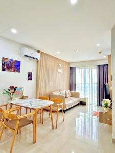ein Wohnzimmer mit Sofa und Tisch in der Unterkunft Love Family Homestay, Nera Garden Apartment Huế in Thôn Văn Dương