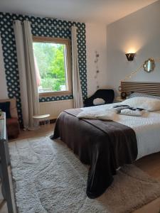 a bedroom with a large bed and a window at L'Essentiel in Oherville