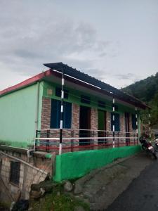 a house with a motorcycle parked in front of it at Khoyal home stay in Jāmb