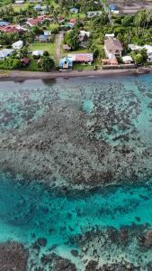 una vista aerea dell'oceano con case e un resort di Hava'e Lodge TEAHUPOO a Teahupoo